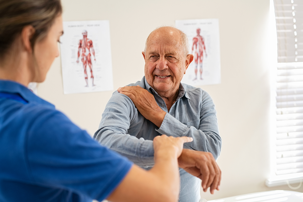 Chiropractic checking elbow and shoulder joint pain of old patient - Enlightened Chiropractic