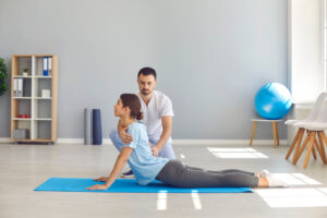 a young athlete performing a back-bending exercise during physiotherapy after a sports injury - Exercises to Complement Your Chiropractic Treatments