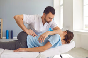A skilled New orleans chiropractor performing gentle hand movements during a treatment session in a manual therapy clinic, showcasing professional chiropractic care in action.