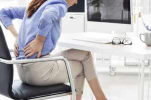 Businesswoman experiencing chronic back pain seeking a New Orleans chiropractor 