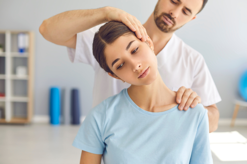 A chiropractor expertly treating a woman's neck during a therapy session, showcasing professional chiropractic care for neck and shoulder pain relief.