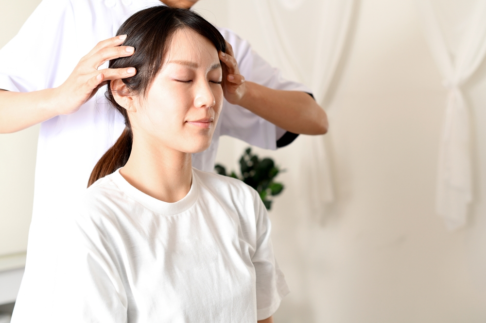 Young Asian woman receiving a manipulative head massage from a chiropractor - New Orleans chiropractor