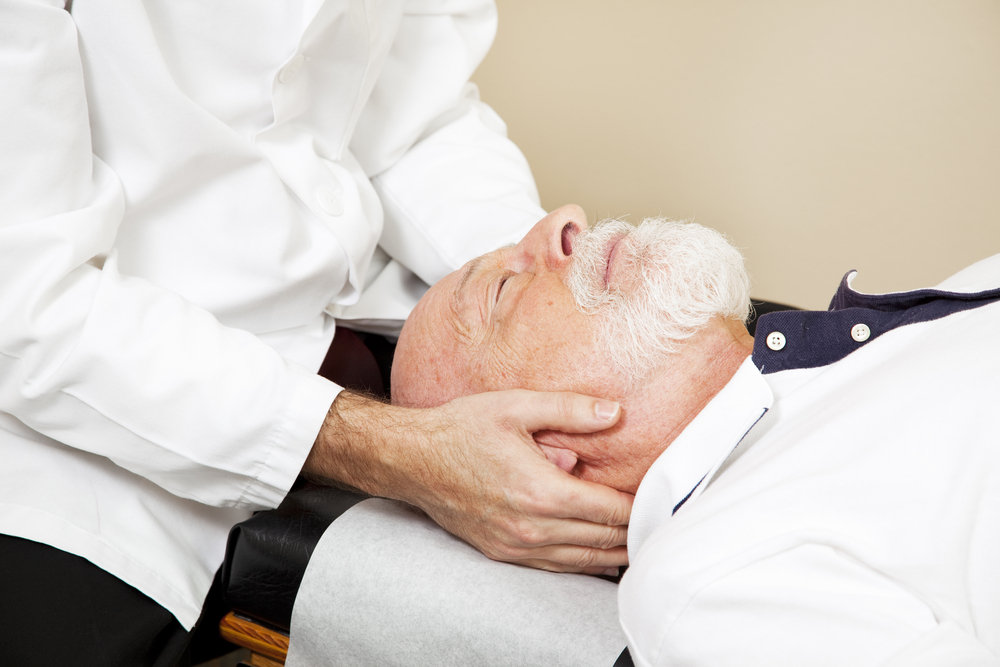 Closeup of a chiropractor adjusting a senior patient's cervical spine demonstrating personalized chiropractic care for enhanced senior health.
