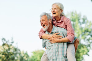 Joyful senior couple enjoying their golden years outdoors, embodying the benefits of chiropractic care in maintaining an active and healthy lifestyle.